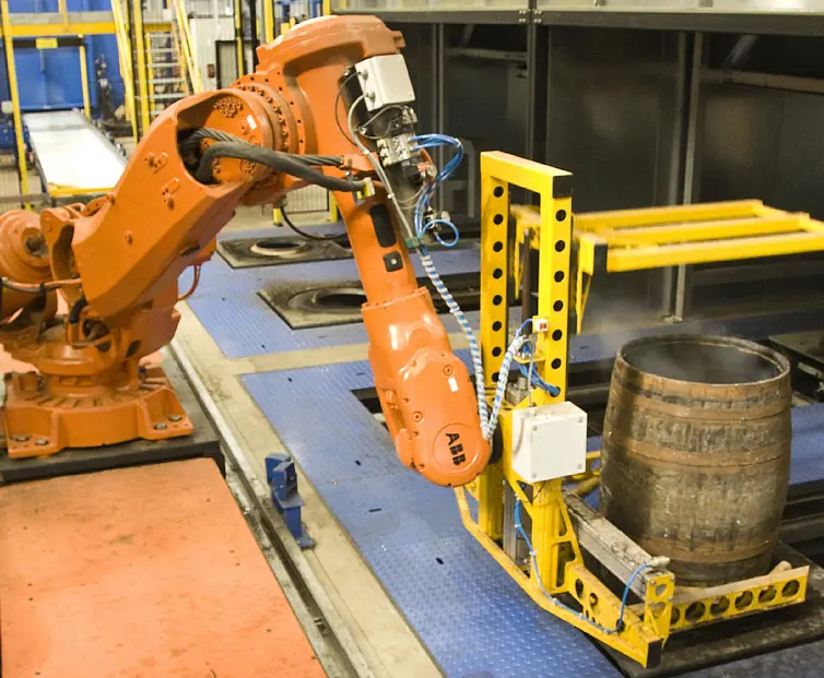 Robotic conveyor system moving barrels.