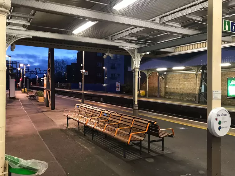 empty bench next to platform in a train station.