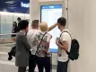 People using a wall mounted touchscreen to view journey times