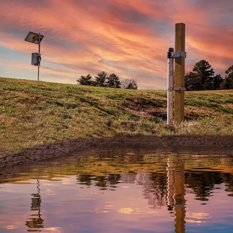 flood monitoring pole with solar panel measuring water levels.