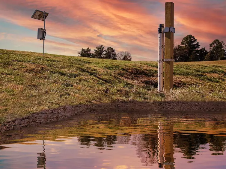 flood monitoring pole with solar panel measuring water levels.