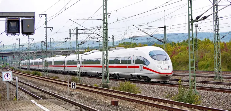 a white high speed train moving along a track at daytime.