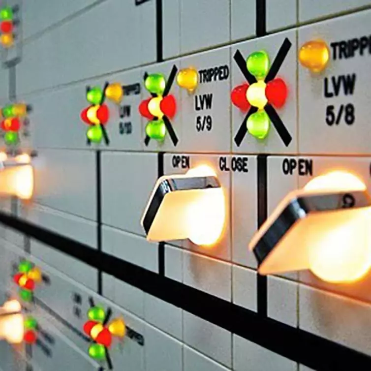 close-up of a control panel with multiple colorful buttons lit up.