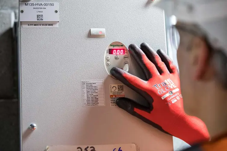 man inspecting electrical equipment in station.