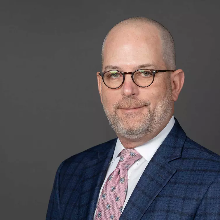 headshot of Greg Lippard, man smiling wearing glasses.