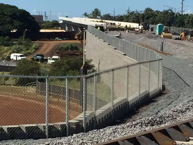 restraining rail shown on a track next to a fence.