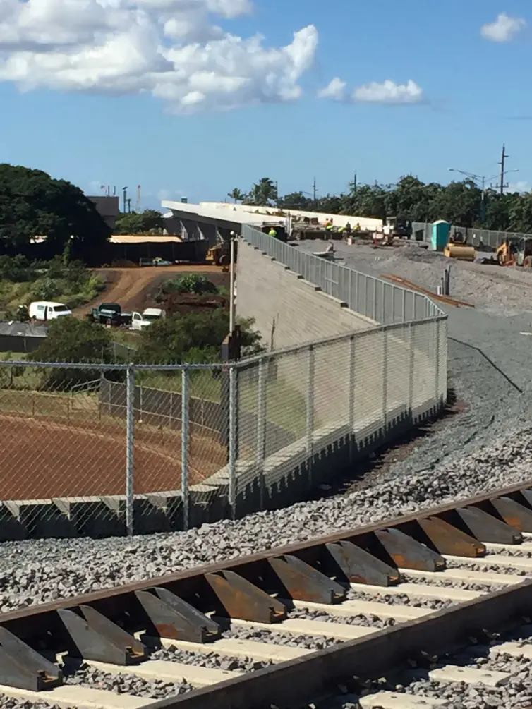 restraining rail shown on a track next to a fence.