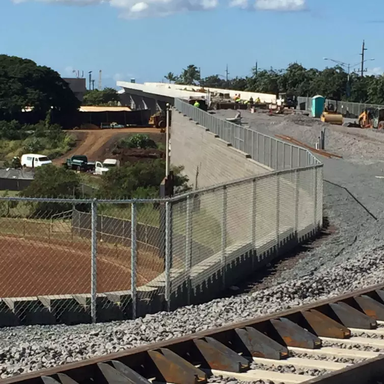 restraining rail shown on a track next to a fence.