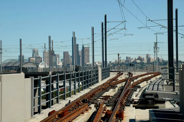 railroad track shown with city skyline in the background.