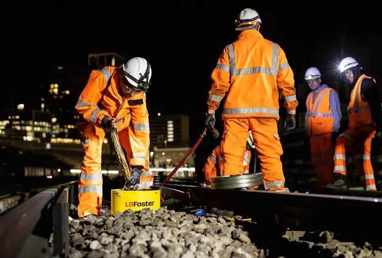Workers in hi-vis equipment working on railway track.